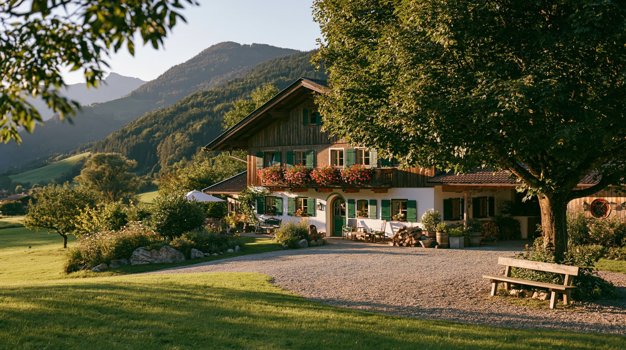 Gasthof zur grünen Weide im Abendlicht, davor Wiese und Kastanie